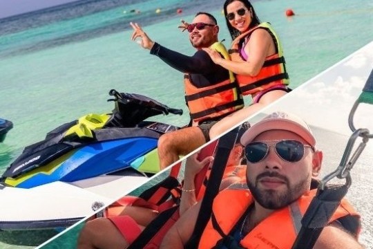 Two people on a jet ski in clear water; man parasailing in an orange vest.